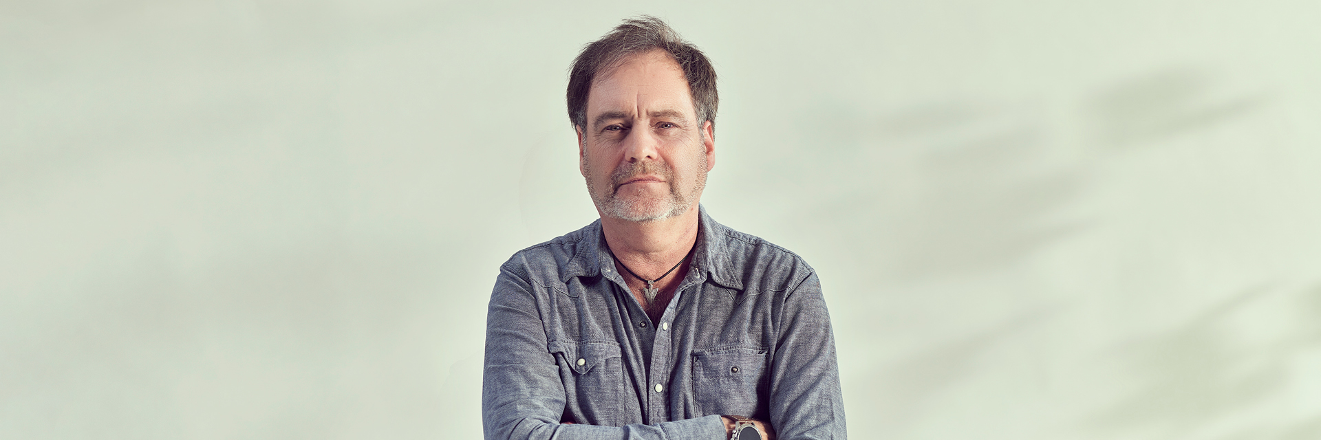 Man looking straight at camera on plain background