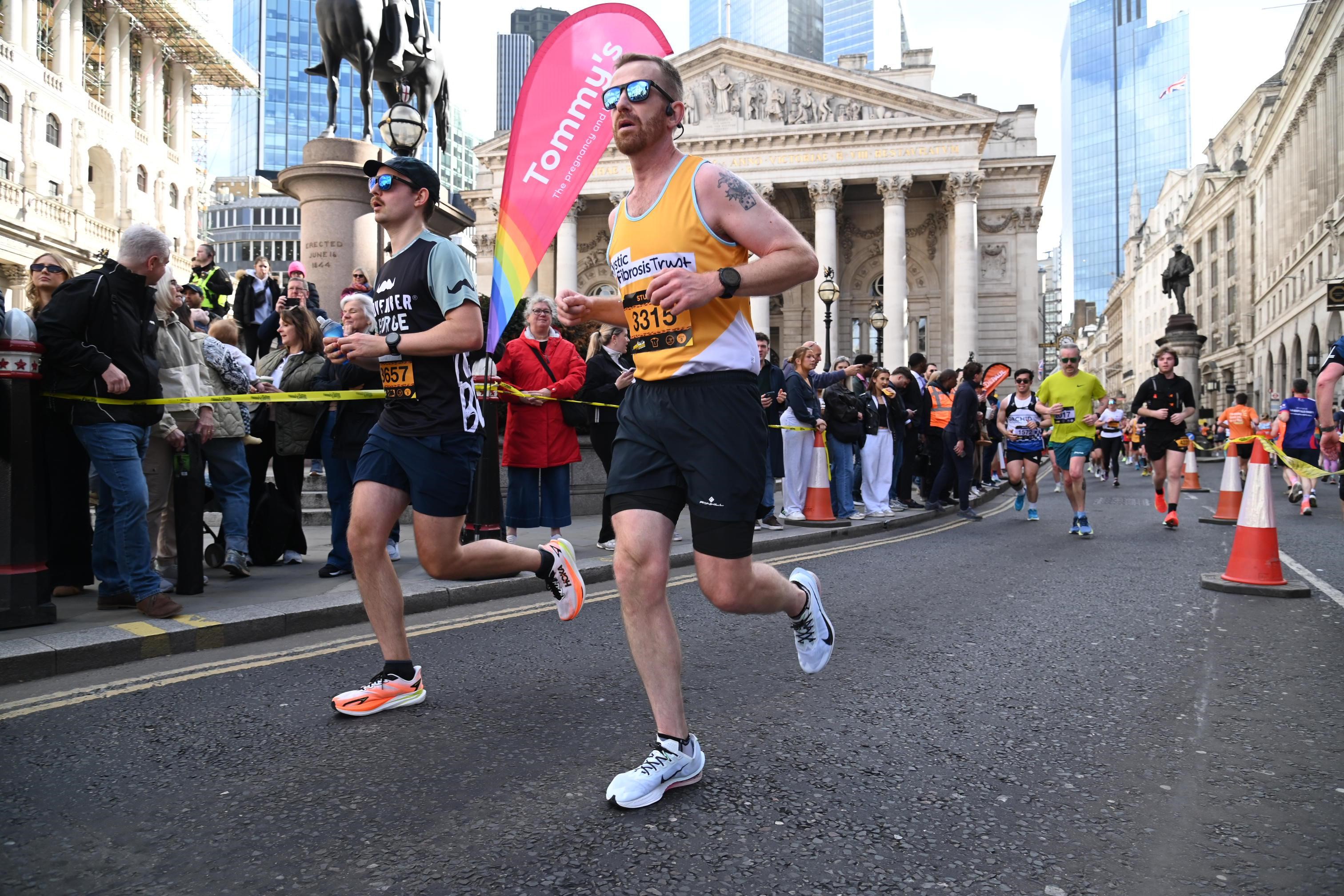 A man running wearing a yellow Cystic Fibrosis Trust top