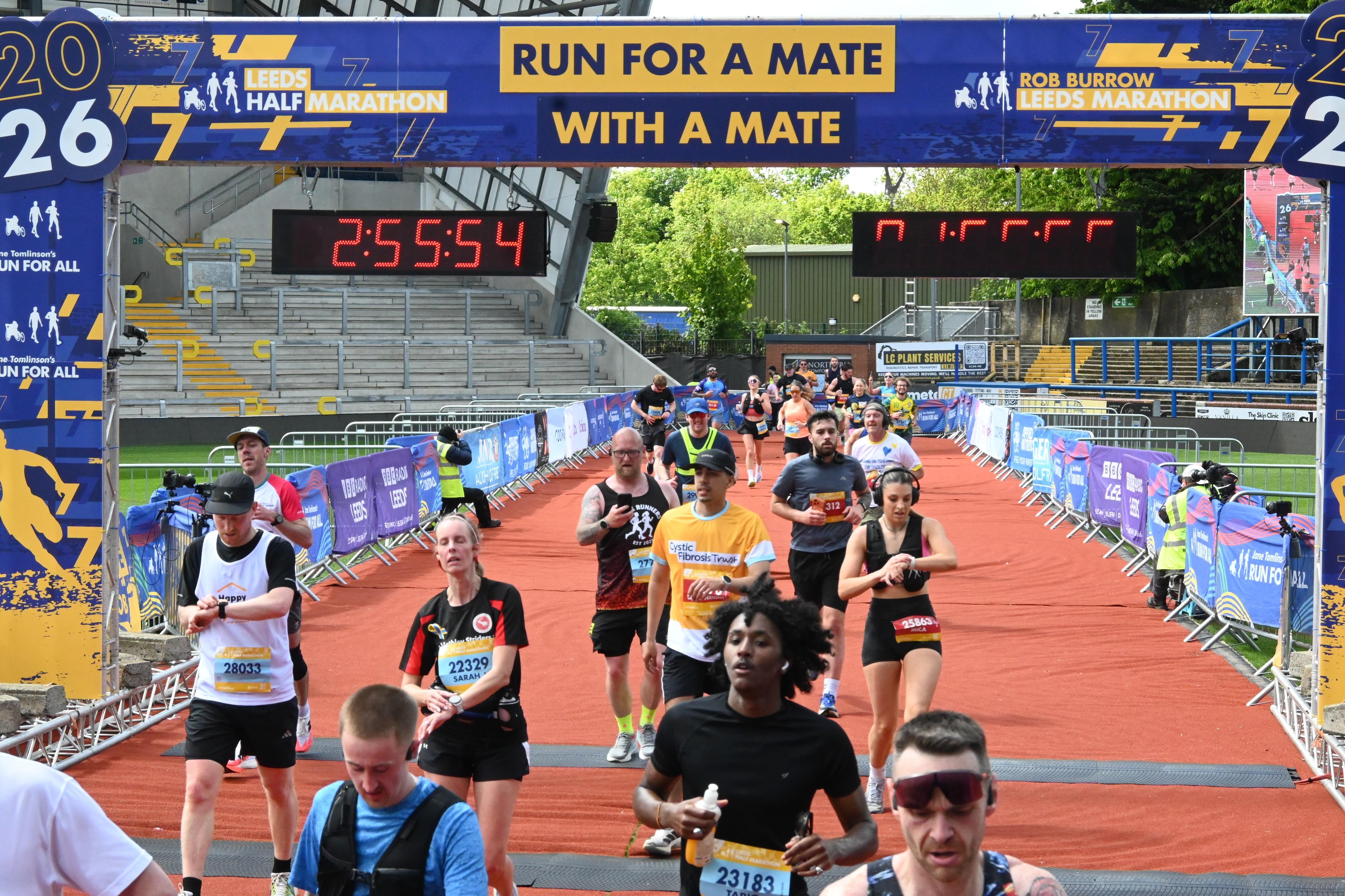 A man running wearing a yellow Cystic Fibrosis Trust top