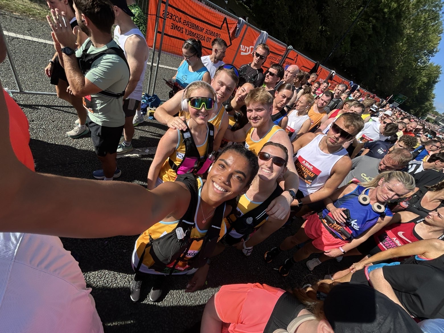 group of runners wearing cystic fibrosis trust tops queuing and smiling before their race