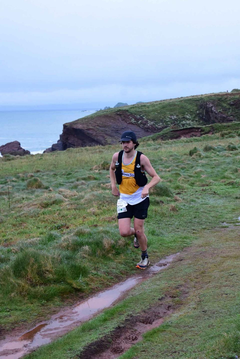 Declan running along a trail wearing a Cystic Fibrosis Trust vest