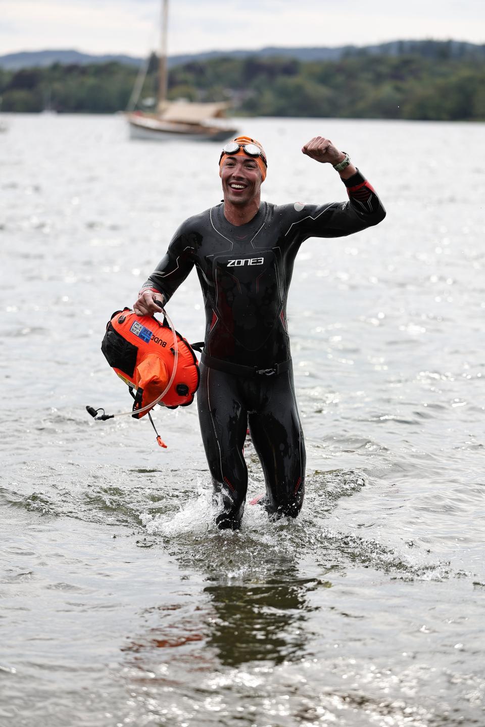 Adam standing in the lake, celebrating at the finish line