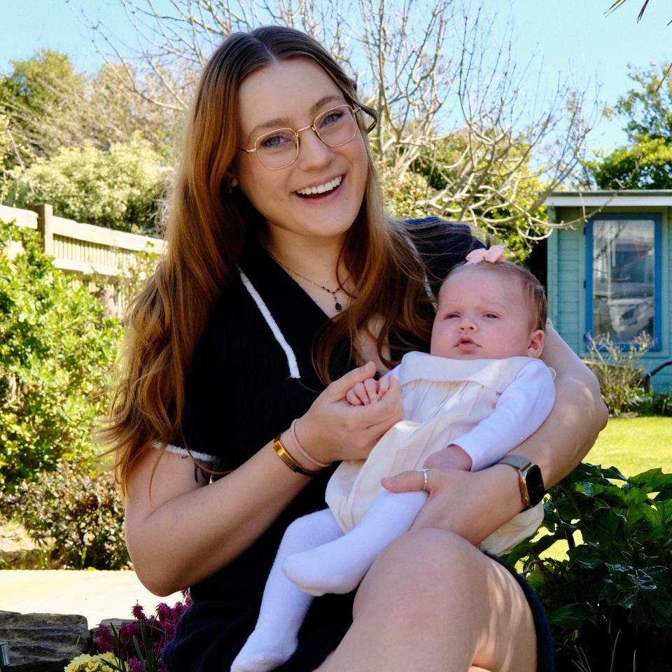 Annabelle sits in the garden with her baby. She looks very happy.