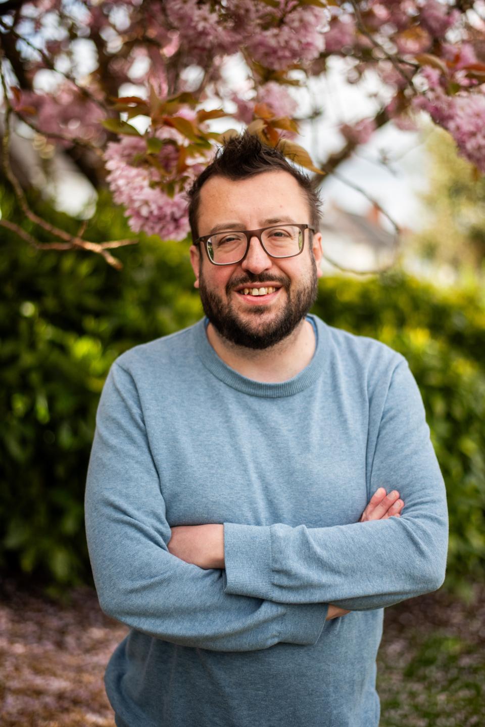 Dan stands smiling