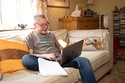 Man sitting on the sofa and looking at laptop