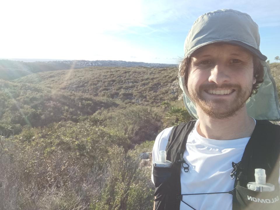 Declan out running in nature, smiling at camera