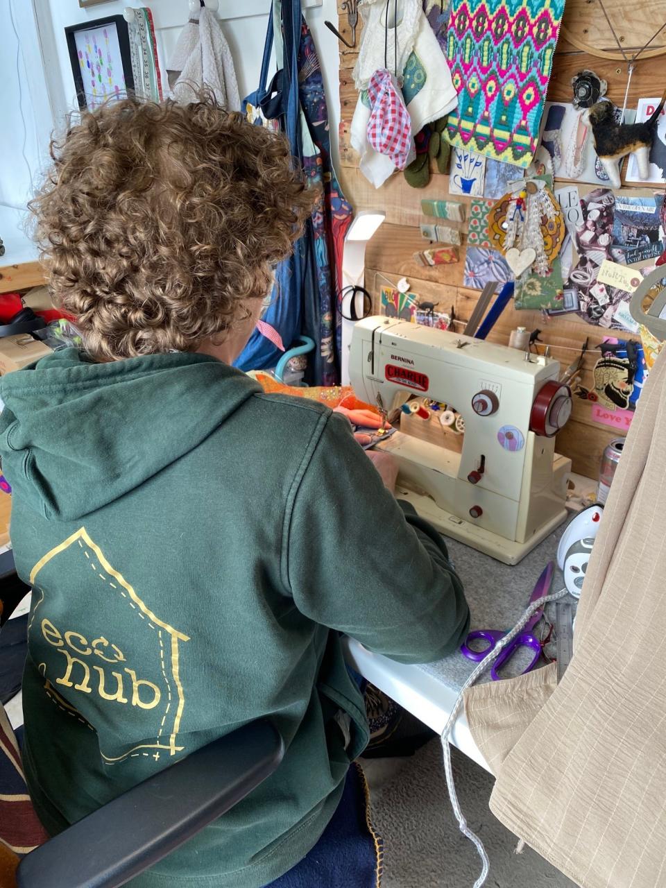 Louise sits at her sewing machine