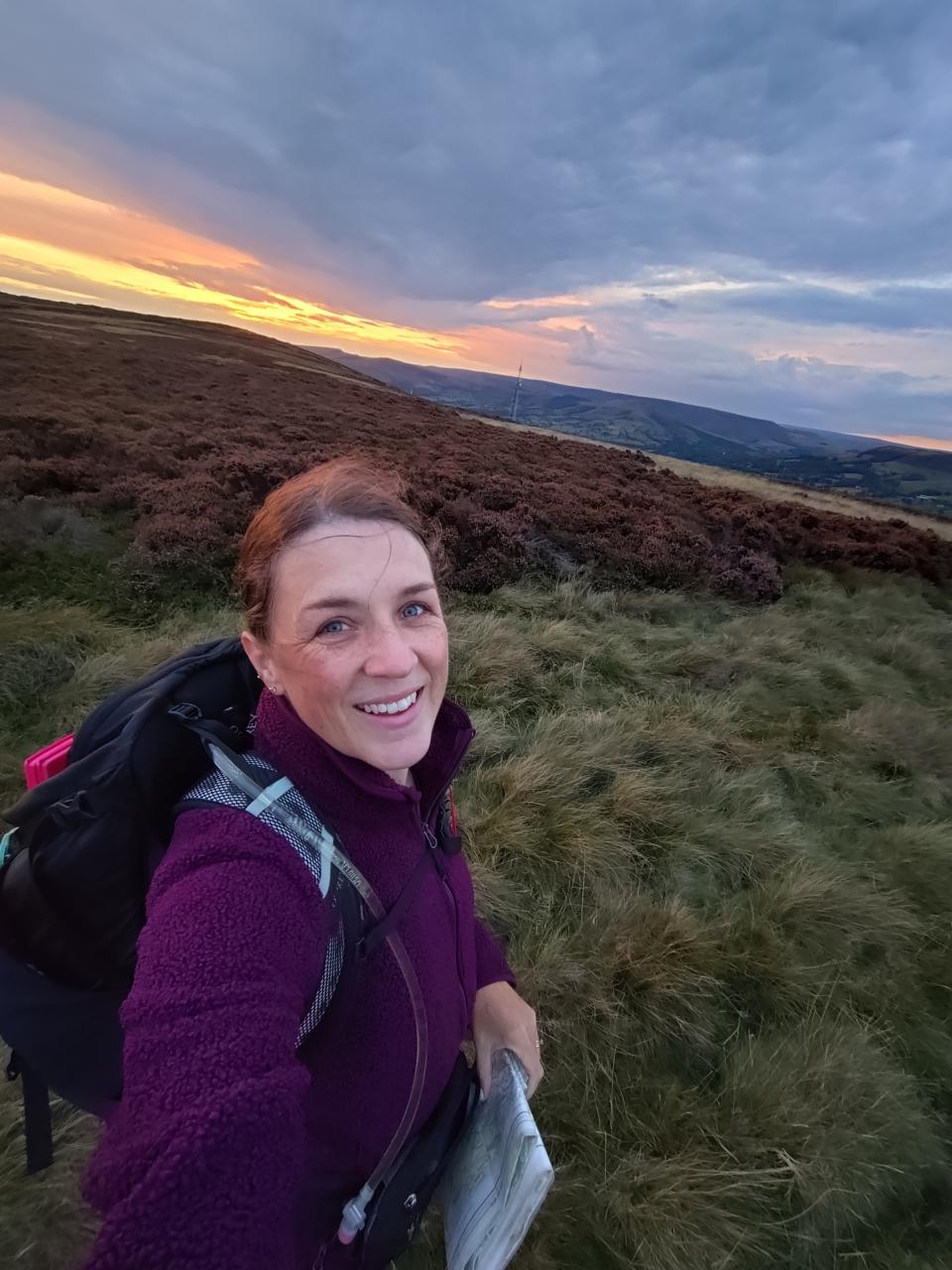 Sara stands in front of sunset