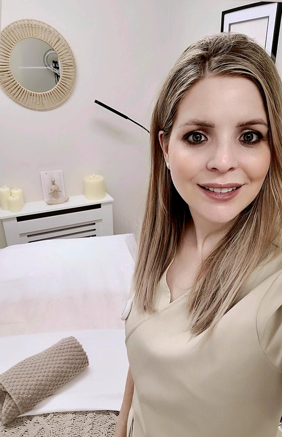Sammy stands in her studio, smiling