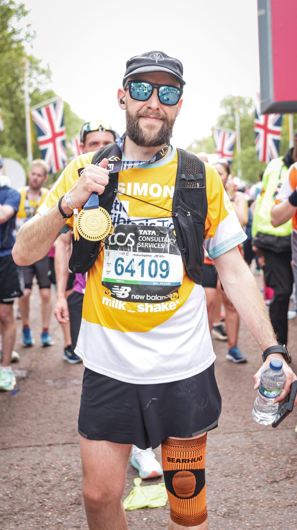 Simon holds up his medal at the finish line of the London Marathon