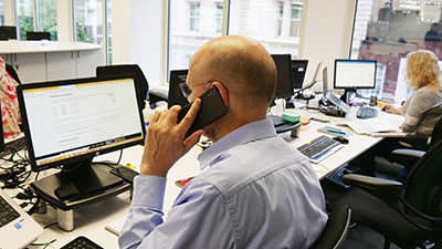 Man answering a call to our Helpline
