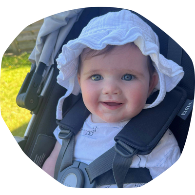 Matilda, a little baby wearing a hat outside in the pram