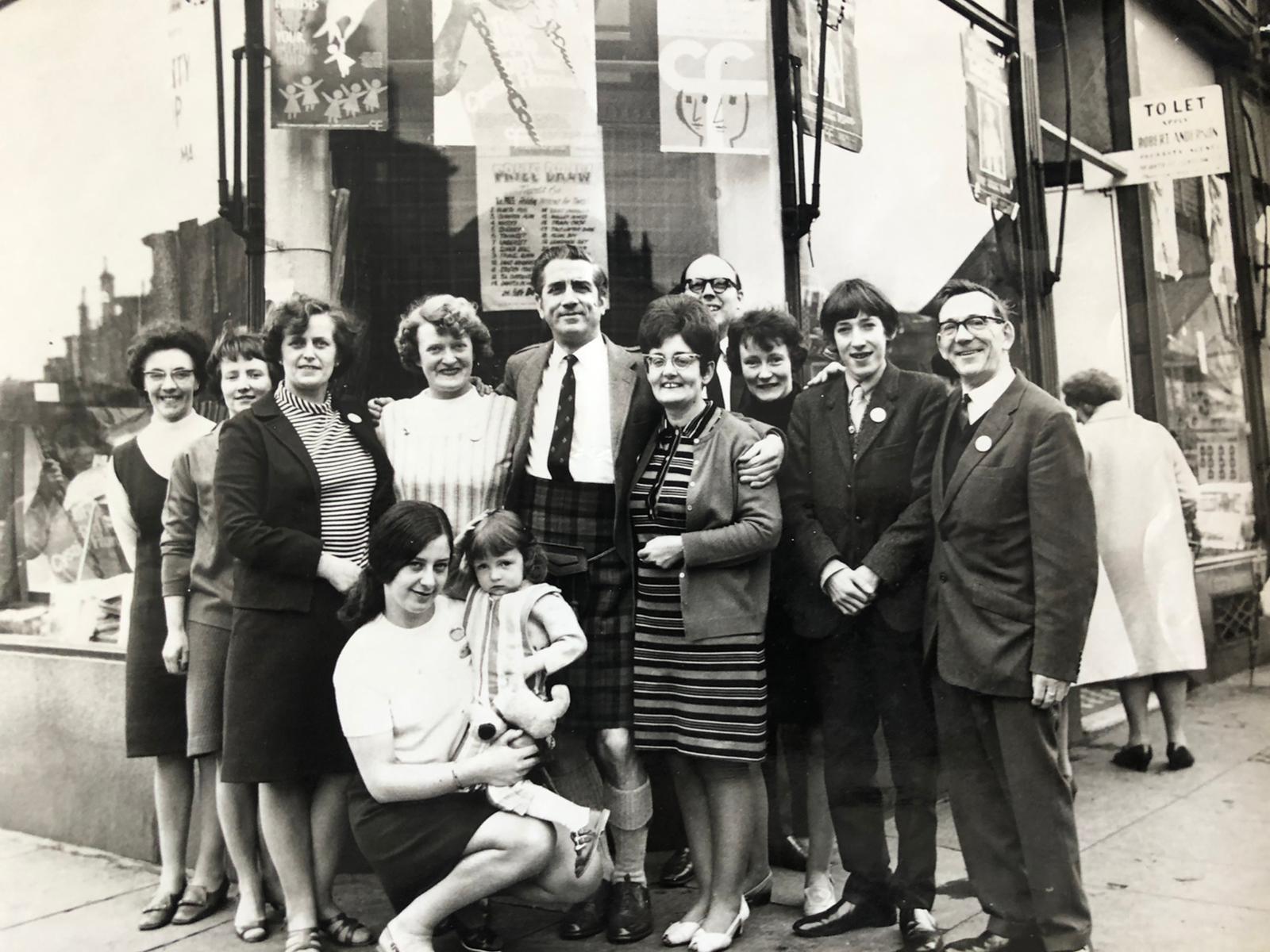 Paul's mother Betty (left of man in kilt) in 1966 at the charity shop in Byres Road, Glasgow with actor and comedian Jonny Beattie