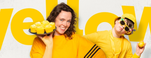People dressed in yellow holding cakes