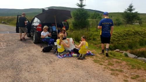 Group of walkers have a break with their support team and vehicle