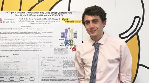 Photo of man standing by scientific poster