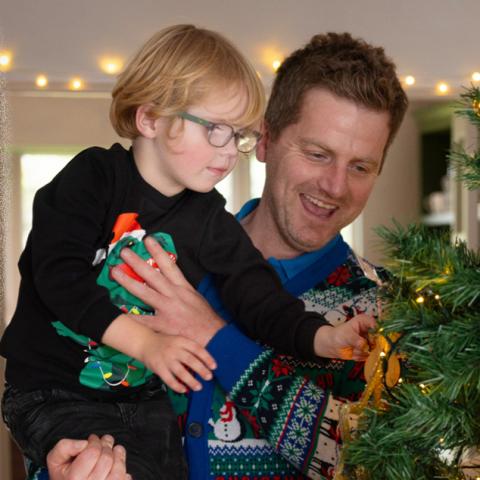 Little boy and dad looking at Christmas tree