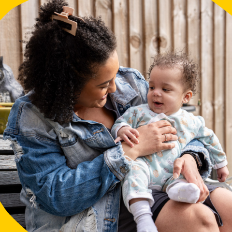 Shanique holding baby Thiago, who has CF; they're sitting on a bench in her garden