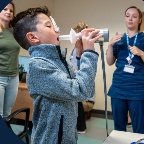 a young boy doing a lung function test in hospital