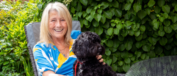 Jane, who has CF, sitting outside with a dog on her lap