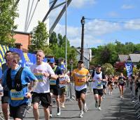 A man running wearing a yellow Cystic Fibrosis Trust top