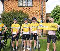 a group of people on bikes cheering in yellow cystic fibrosis trust tops