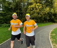 2 men running in cystic fibrosis trust yellow tops with yellow Santa hats