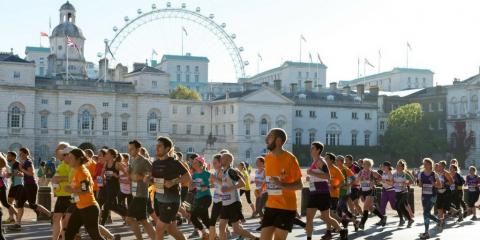 Large group of people running a marathon with the London Eye in the background