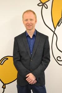 White man wearing a suit with a blue shirt