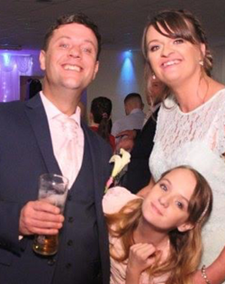 Woman, man and young girl posing together at a party