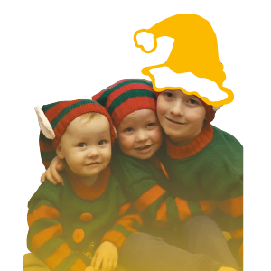 Three young children wearing red and green elf outfits