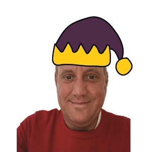 Middle-aged white man smiling and wearing an elf hat and red jumper