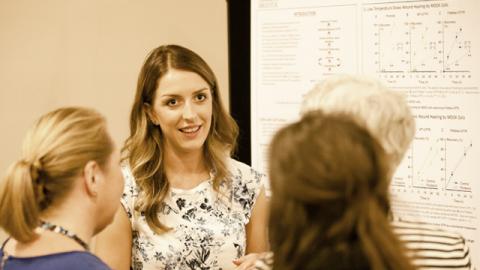 Young woman presenting a research poster