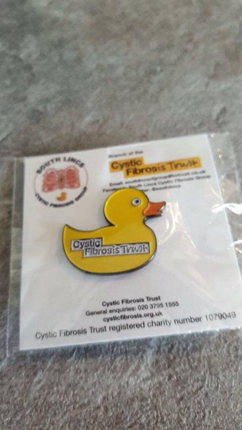 Ayellow duck badge in a white packet.