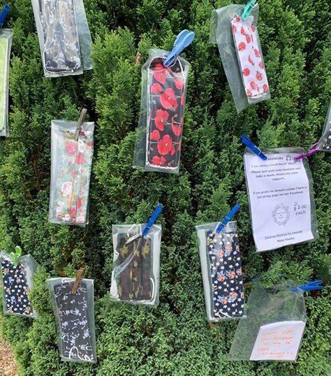 Homemade face masks pinned to a tree with a note for people to make donations