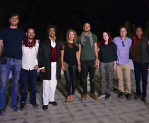 A group of people stand in a line smiling at the camera.