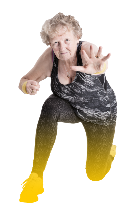 older woman kneeling on one knee striking superhero-like pose with hands