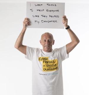Liam McHugh holding sign saying 'I want trials to help everyone like they helped my daughter'