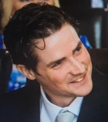 Young man with dark hair wearing a suit