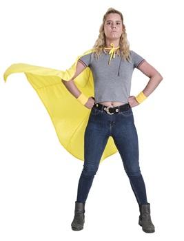 Girl was blonde hair standing with hands on hips wearing grey t-shirt and jeans wearing yellow superhero cape 