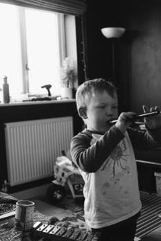 Black and white photo of young boy playing recorder
