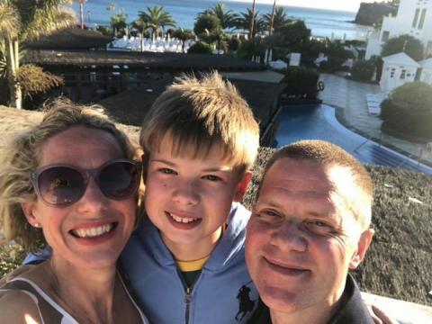 Tim with his wife Kate and their son Felix in front of a beach