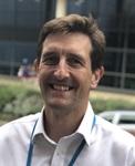 man with open neck shirt smiles into the camera. The man is Dr Thomas Daniels Consultant Respiratory Physician