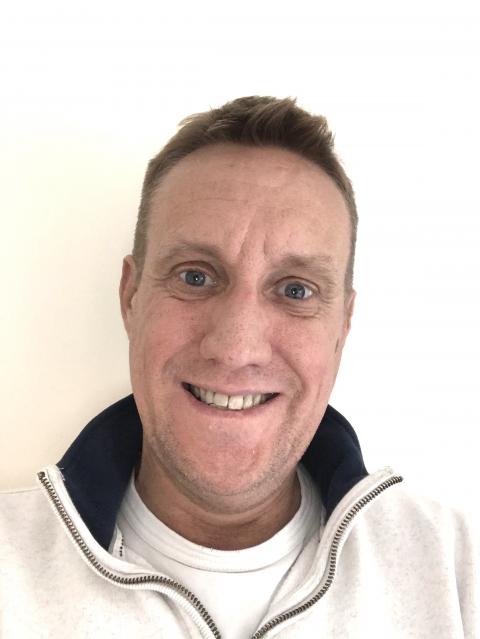 Middle-aged white man smiling at the camera