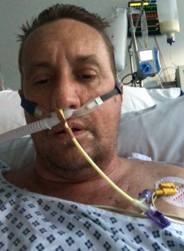 Man in hospital bed hooked up to machines