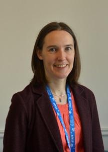 Young white woman in jacket and wearing a lanyard