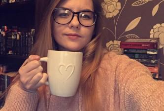 Young woman holding up a mug of tea