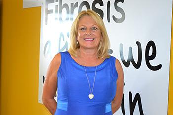 Smiling white woman in bright blue top