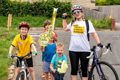 Woman and four children with banners and bikes