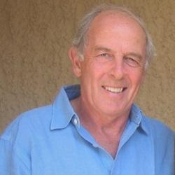 Older white man wearing casual blue shirt. He is smiling.